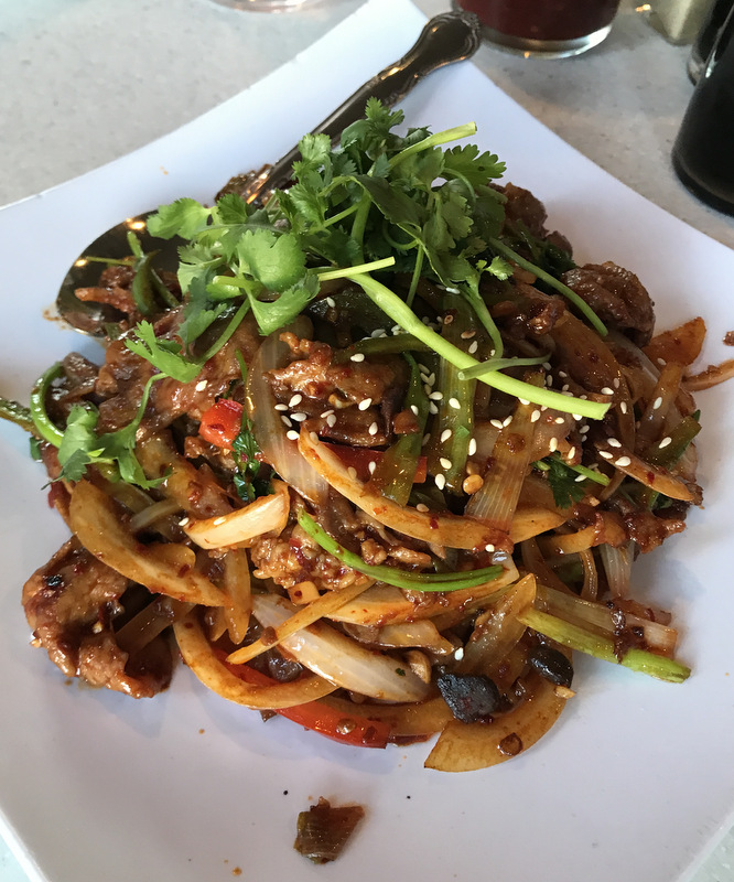Chinese eggplant with basil and mushrooms, topped with sesame seeds, cilantro, and stir-fried onions