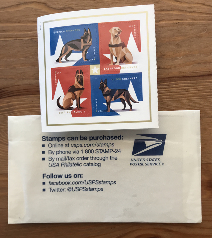 USPS envelope with information on where to purchase stamps, including website link: usps.com/stamps. Also four USA Forever Stamps with pictures of different dog breeds on them.