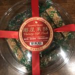 Round container of nuts-and-sesame sticks for lunar new year