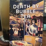 Death by Bubble Tea novel by Jennifer J. Chow next to alishan bubble tea