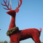 red reindeer statue with holiday wreath